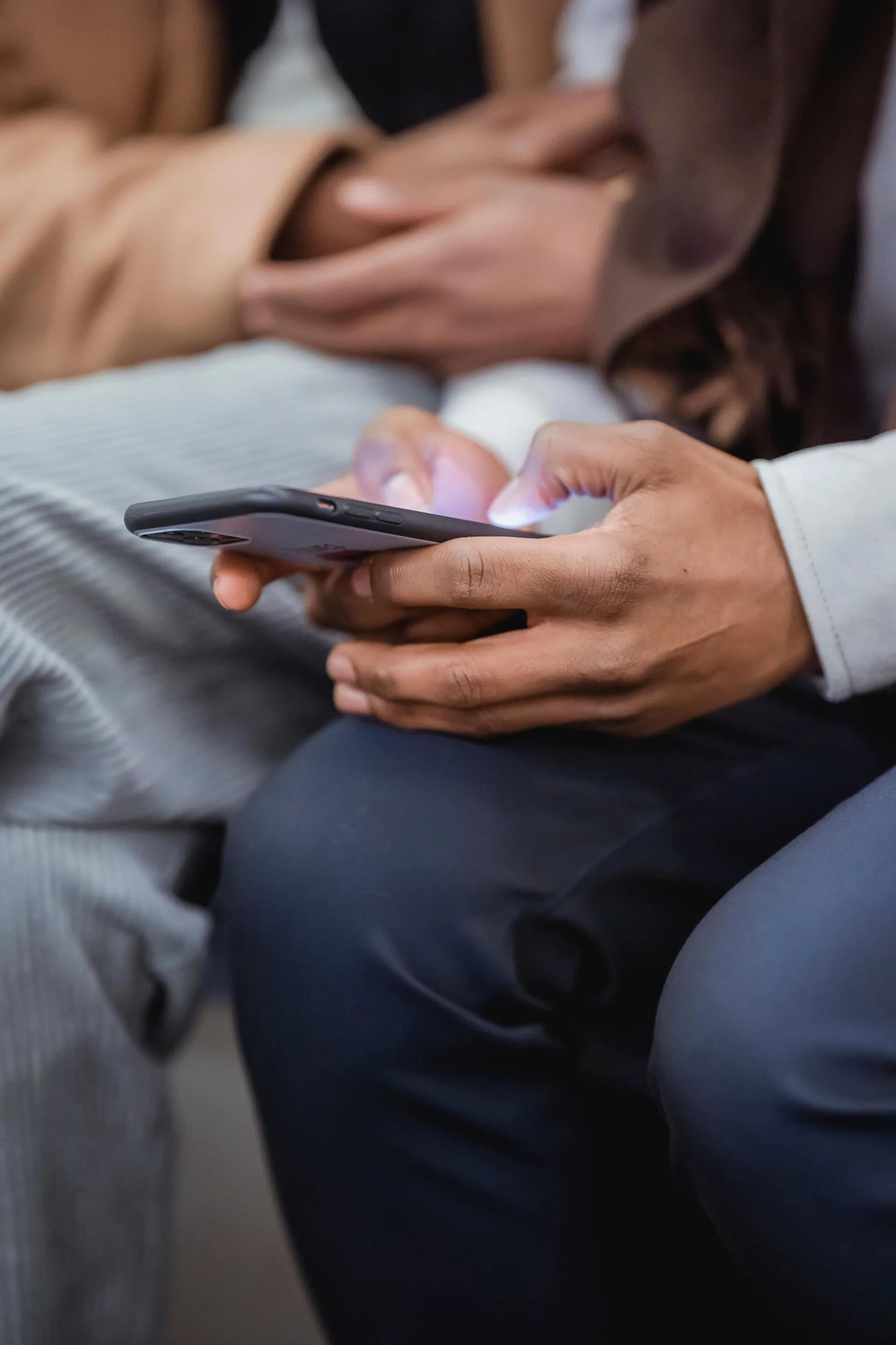 Güneşli bir caddede telefonuna mesaj yazan biri